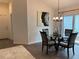 Dining area features a glass-top dining table with chandelier and adjacent access to backyard at 680 Joseph Way, The Villages, FL 34762