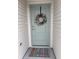 Charming front door with a welcoming wreath and colorful doormat enhancing curb appeal at 680 Joseph Way, The Villages, FL 34762