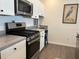 Close-up of the modern kitchen with stainless steel appliances and neutral countertops and wood flooring at 680 Joseph Way, The Villages, FL 34762