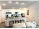 Well-lit kitchen with white cabinets, stainless appliances, and barstool seating at 680 Joseph Way, The Villages, FL 34762