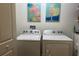 Well-lit laundry room featuring modern appliances and stylish artwork creating a functional space at 680 Joseph Way, The Villages, FL 34762