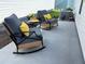 Cozy backyard patio featuring comfortable rocking chairs with plush cushions and a small table at 680 Joseph Way, The Villages, FL 34762