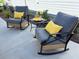 Comfortable outdoor patio set with cushioned rocking chairs and vibrant yellow pillows on a concrete patio at 680 Joseph Way, The Villages, FL 34762