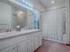 Bathroom featuring double sinks, tile flooring, and a shower-tub combo with curtain at 712 Old Oaks Ln, Leesburg, FL 34748