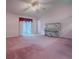 Spacious bedroom featuring plush pink carpeting, a ceiling fan, and sliding glass doors at 712 Old Oaks Ln, Leesburg, FL 34748