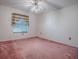 Clean and spacious bedroom with a large window, ceiling fan, and wall to wall carpeting at 712 Old Oaks Ln, Leesburg, FL 34748