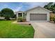 Charming single-story home with a well-maintained lawn and an attached two-car garage at 712 Old Oaks Ln, Leesburg, FL 34748