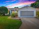 Charming single-story home with a well-maintained lawn and an attached two-car garage at 712 Old Oaks Ln, Leesburg, FL 34748
