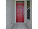 Inviting front entrance with a red door, tiled landing, and white siding at 712 Old Oaks Ln, Leesburg, FL 34748