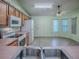 Functional kitchen with wood cabinets, white appliances, and a convenient breakfast bar at 712 Old Oaks Ln, Leesburg, FL 34748