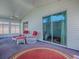 Enclosed lanai with white wicker furniture and ceiling fan at 712 Old Oaks Ln, Leesburg, FL 34748