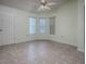 Bright living room with multiple windows, a ceiling fan, and neutral flooring; door provides easy access to the outside at 712 Old Oaks Ln, Leesburg, FL 34748