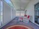 Inviting sunroom featuring plush carpeting, white wicker furniture with vibrant red cushions, and ample natural light at 712 Old Oaks Ln, Leesburg, FL 34748