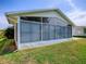 Exterior view of the sunroom, featuring large windows and well-maintained surrounding yard at 712 Old Oaks Ln, Leesburg, FL 34748
