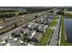 New construction homes line a street in a planned community with manicured lawns near a highway at 7955 Delwin Ln, Reunion, FL 34747