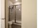 Bathroom with glass enclosed walk-in shower, toilet, and white walls at 7955 Delwin Ln, Reunion, FL 34747