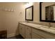 Dual sink bathroom vanity featuring granite countertops, framed mirrors, and neutral paint at 7955 Delwin Ln, Reunion, FL 34747
