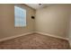 An empty carpeted bedroom features a window with blinds and neutral colored walls at 7955 Delwin Ln, Reunion, FL 34747