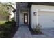 Front entry with stone pillar and glass paneled door next to the 2 car garage at 7955 Delwin Ln, Reunion, FL 34747