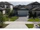 Aerial view of a home with a two-car garage, stone accents, and a stone driveway at 7955 Delwin Ln, Reunion, FL 34747