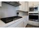 Close up of a kitchen featuring stainless steel appliances, gas cooktop, and white countertops at 7955 Delwin Ln, Reunion, FL 34747