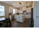 Open kitchen with an island, white cabinets, stainless steel appliances and a dining table at 7955 Delwin Ln, Reunion, FL 34747