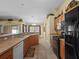 Kitchen features neutral counters, wood cabinets, and black appliances with a breakfast bar at 847 Cumberland Cir, Minneola, FL 34715