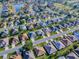 An aerial view of a neighborhood with lush landscaping, a pond, and golf course at 8601 Se 133Rd St, Summerfield, FL 34491