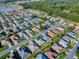 Beautiful aerial view of a neighborhood with lush landscaping, trees, and a pond at 8601 Se 133Rd St, Summerfield, FL 34491