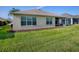 Well-maintained backyard featuring a screened lanai, lush green lawn, and privacy landscaping at 8601 Se 133Rd St, Summerfield, FL 34491