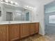 Bathroom featuring double vanity, framed mirrors, tiled floor, and access to other rooms at 8601 Se 133Rd St, Summerfield, FL 34491