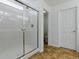 Bathroom showcasing a glass-enclosed shower, tiled floor, and a doorway to the toilet room at 8601 Se 133Rd St, Summerfield, FL 34491