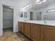 Bathroom featuring a double vanity with wood cabinets, framed mirrors, and a glass-enclosed shower at 8601 Se 133Rd St, Summerfield, FL 34491