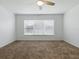 Bedroom featuring plush carpet, a large window with blinds, and a ceiling fan at 8601 Se 133Rd St, Summerfield, FL 34491