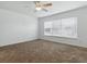 Bright bedroom with plush carpet flooring, large window with blinds, and a ceiling fan at 8601 Se 133Rd St, Summerfield, FL 34491