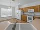 Bright kitchen featuring white appliances, wooden cabinetry, and a view of the sink area at 8601 Se 133Rd St, Summerfield, FL 34491