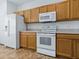 View of the kitchen featuring white appliances and light wood cabinets at 8601 Se 133Rd St, Summerfield, FL 34491