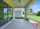 Covered lanai featuring a ceiling fan, ample space, and tranquil outdoor views at 8601 Se 133Rd St, Summerfield, FL 34491