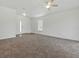 Bright, open living room with neutral carpet, ceiling fan, and front door access at 8601 Se 133Rd St, Summerfield, FL 34491