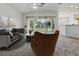 Stylishly furnished living room featuring comfortable seating and a view of the backyard through sliding glass doors at 8601 Se 133Rd St, Summerfield, FL 34491