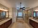 Luxurious main bathroom featuring double vanities, a soaking tub, and a glass-enclosed shower at 8719 Kenmure Cv, Orlando, FL 32836