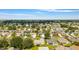 This wide aerial shot shows a vibrant residential community with manicured lawns and beautiful homes under a clear blue sky at 965 Eastmont Ct, The Villages, FL 32162