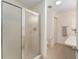 Bright bathroom featuring a glass shower door and a matching tiled floor at 965 Eastmont Ct, The Villages, FL 32162