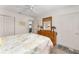 A bedroom shows a dresser, closet, and white doors with a ceiling fan at 965 Eastmont Ct, The Villages, FL 32162