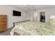 Spacious bedroom showcasing wood-look floors, a floral bedspread, and a TV at 965 Eastmont Ct, The Villages, FL 32162
