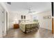 Sunlit bedroom featuring wood-look floors, a decorative bed frame, and a ceiling fan at 965 Eastmont Ct, The Villages, FL 32162