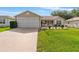 Charming single-story home with a well-manicured lawn and an attached two-car garage at 965 Eastmont Ct, The Villages, FL 32162