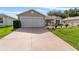 Charming single-story home with a well-manicured lawn and an attached two-car garage at 965 Eastmont Ct, The Villages, FL 32162