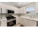 Functional kitchen with stainless steel appliances and white cabinets at 965 Eastmont Ct, The Villages, FL 32162