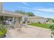 Back patio area with chairs, tables, and a manicured landscape offering an inviting outdoor space at 965 Eastmont Ct, The Villages, FL 32162